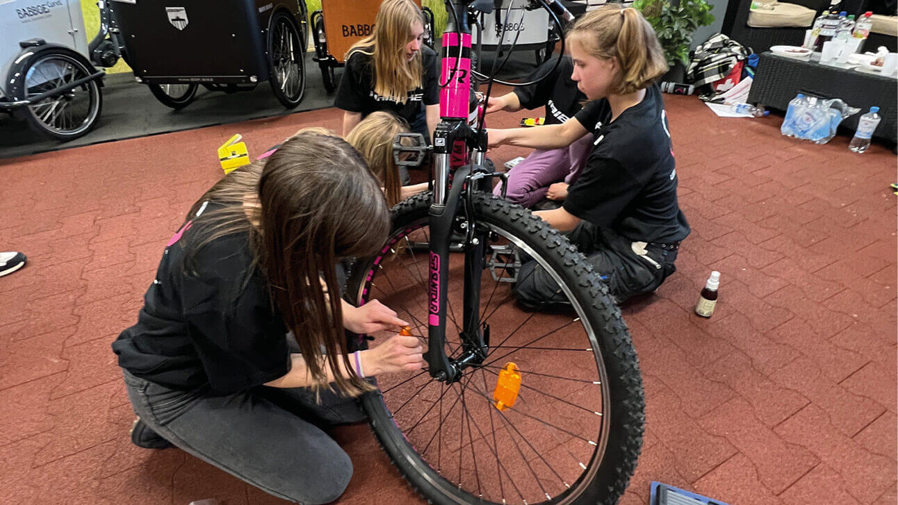 Mädchen helfen bei Reparaturarbeiten an einem Fahrrad