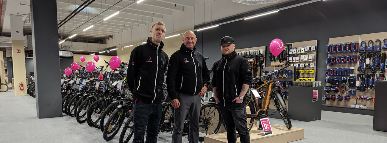 In der Little John Bikes Filiale in Eisenach stehen drei junge Männer und Mitarbeiter nebeneinander vor Fahrrädern