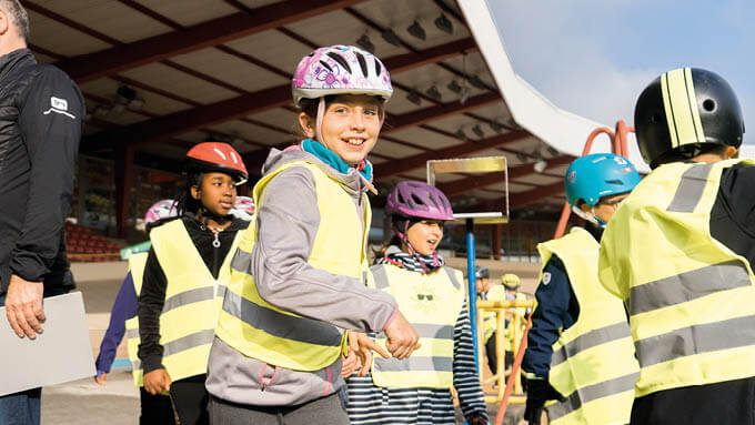 Kinder mit Warnwesten und Fahrradhelm beim Pedalino Camp 2021