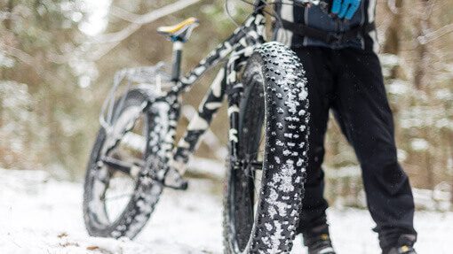 Ein Fahrrad wird durch Schnee geschoben