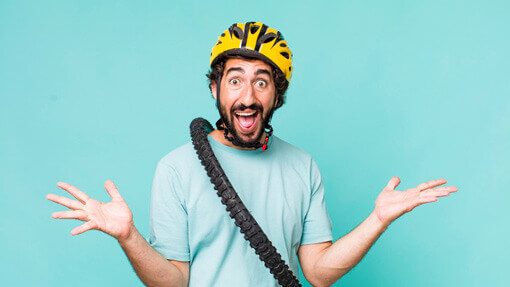 Witziger Mann mit gelbem Helm und Fahrradreifen um den Hals