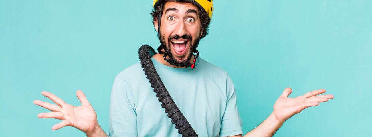 Witziger Mann mit gelbem Helm und Fahrradreifen um den Hals