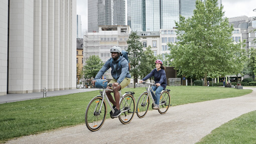 Zwei Fahrradfahrer fahren durch einen Stadtpark
