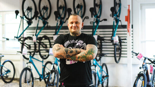 Unser Regionalverkaufsleiter Jens Mütze posiert für ein Foto vor der Fahrradwand in einer Filiale
